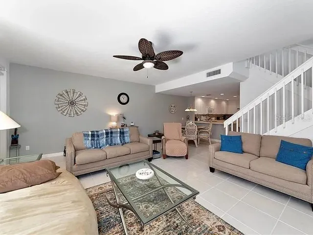 a living room with furniture ceiling fan and a rug