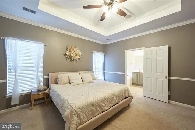 a bedroom with a large bed and ceiling fan