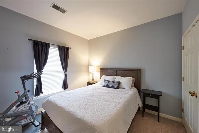 a bedroom with a bed two lamps and a large window