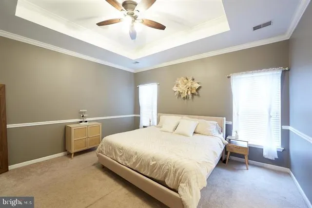 a bedroom with a large bed and ceiling fan