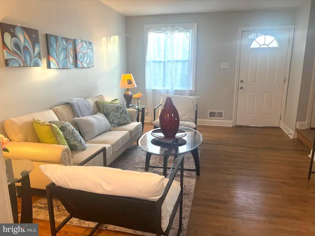a living room with furniture a wooden floor and a window
