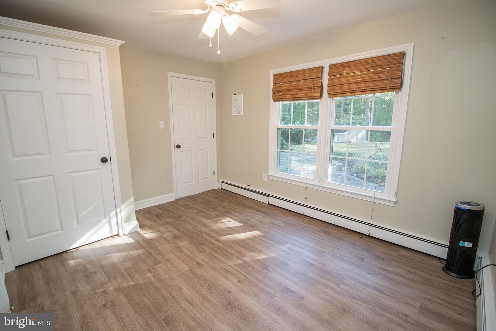 8120 Chapel Point Road Port Tobacco, MD 20677 - Photo 35 of 95 an empty room with wooden floor and windows