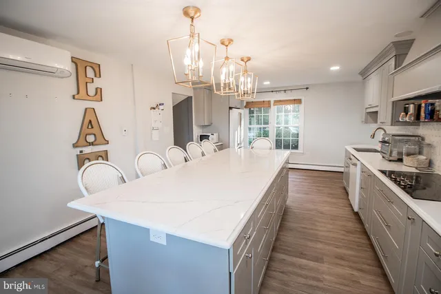 a kitchen with kitchen island a stove a table and chairs in it