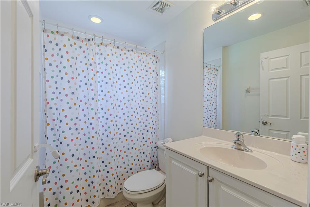 1767 Ribbon Fan Lane Naples, FL 34119 - Photo 15 of 31 Bathroom featuring toilet, vanity, tile patterned floors, and a shower with shower curtain
