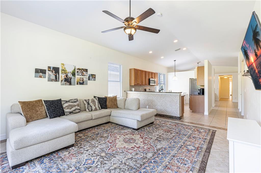 1767 Ribbon Fan Lane Naples, FL 34119 - Photo 5 of 31 Tiled living room featuring ceiling fan and lofted ceiling