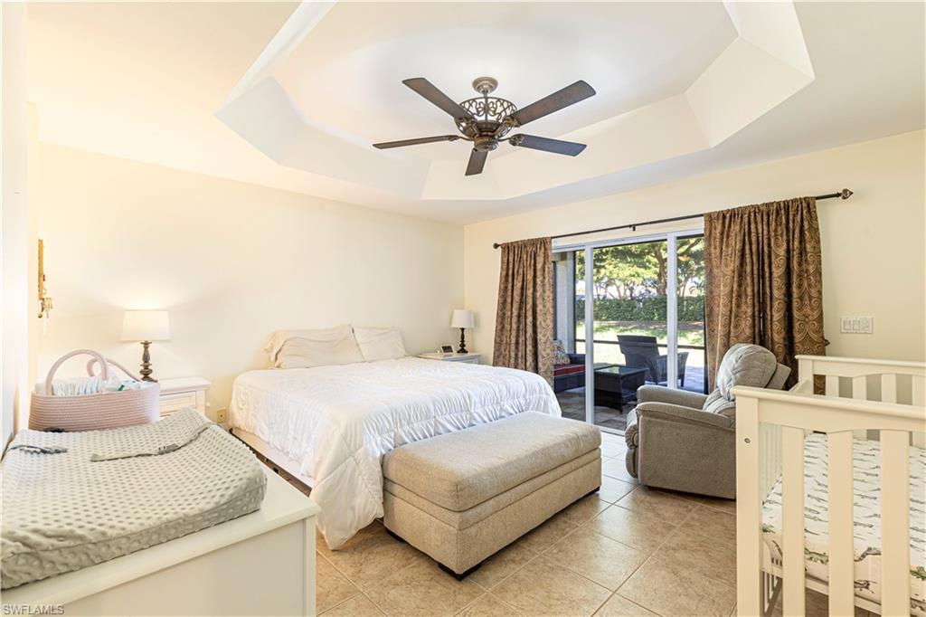 1767 Ribbon Fan Lane Naples, FL 34119 - Photo 9 of 31 Tiled bedroom featuring ceiling fan, a raised ceiling, and access to outside