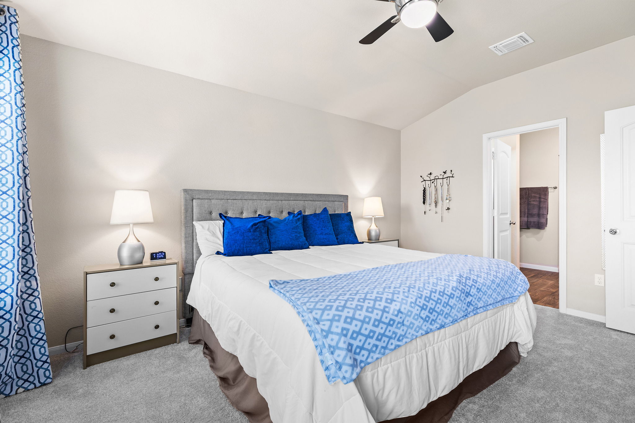 404 Cassandra Drive Hutto, TX 78634 - Photo 6 of 40 Carpeted bedroom featuring ensuite bath, vaulted ceiling, and ceiling fan