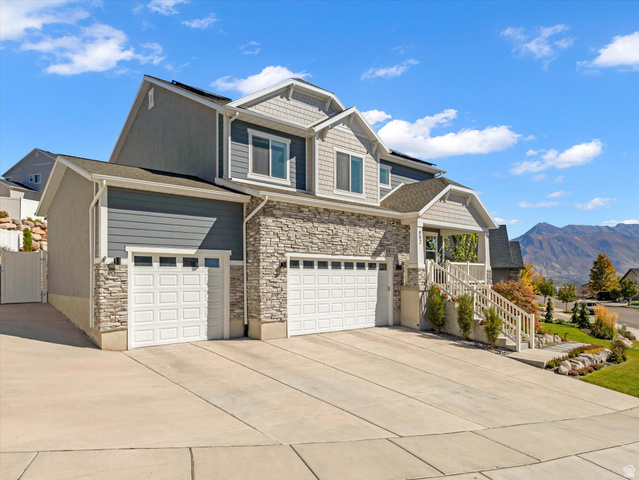 882 Spring Dew Lane Lehi, UT 84048 - Photo 4 of 46 Craftsman inspired home featuring solar panels, concrete driveway, a mountain view, and stone siding