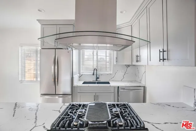 a kitchen with stainless steel appliances a stove a sink and a refrigerator