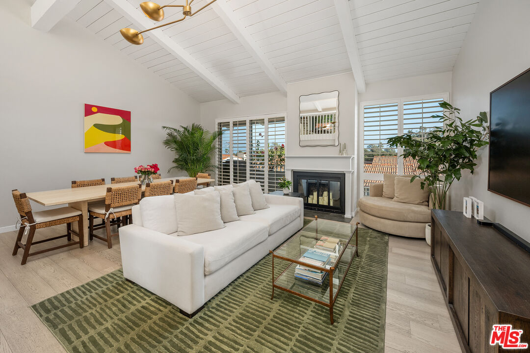 a living room with furniture a rug a fireplace and a flat screen tv