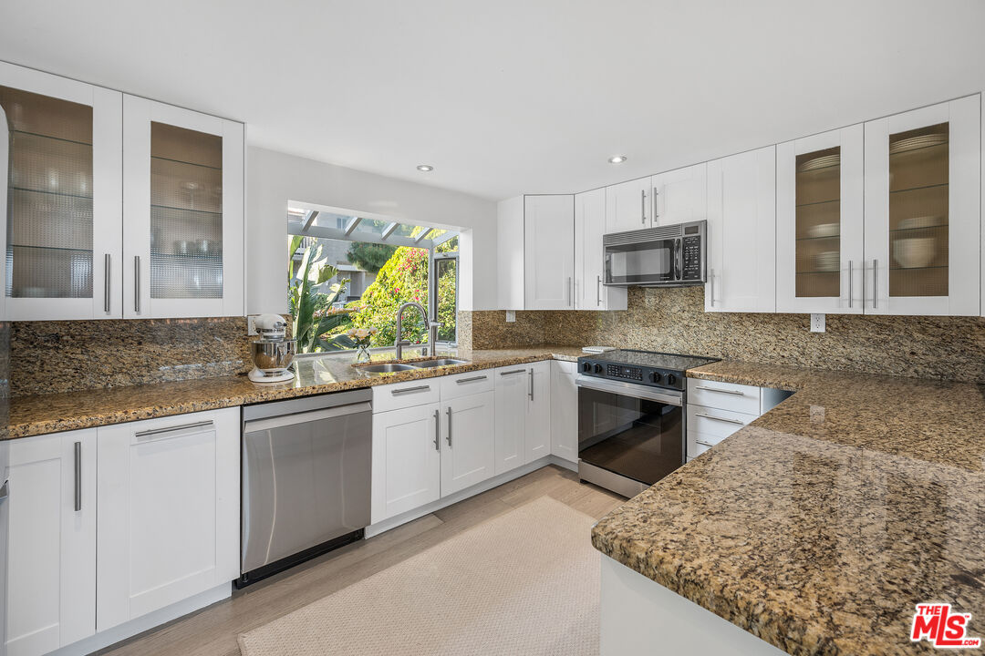 28378 Rey De Copas Lane Malibu, CA 90265 - Photo 15 of 45 a kitchen with stainless steel appliances granite countertop a stove a sink and a microwave