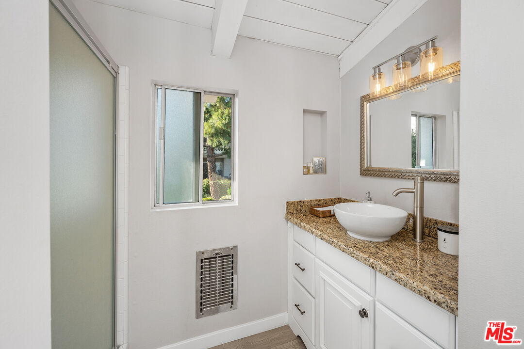 28378 Rey De Copas Lane Malibu, CA 90265 - Photo 24 of 45 a bathroom with a granite countertop sink and a mirror