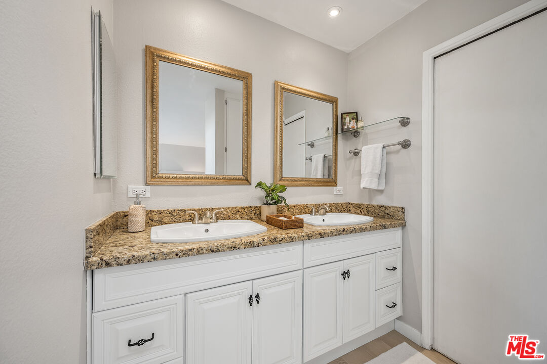 28378 Rey De Copas Lane Malibu, CA 90265 - Photo 29 of 45 a bathroom with a granite countertop sink and a mirror