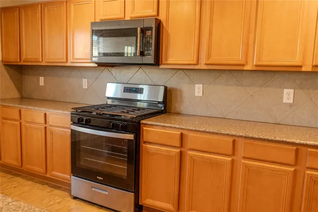 a kitchen with wooden cabinets and a stove top oven
