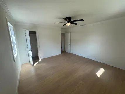 an empty room with a ceiling fan and a window