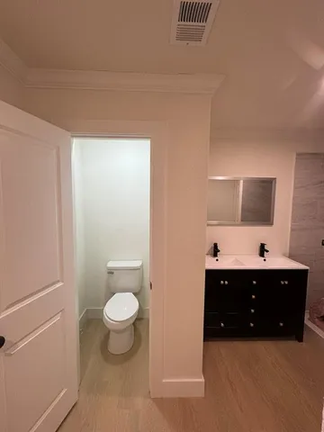a spacious bathroom with a toilet sink and mirror