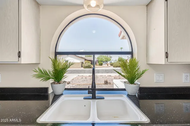 a vase of flowers sitting on a table with window