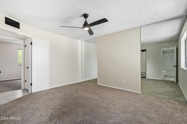 an empty room with a ceiling fan and shower