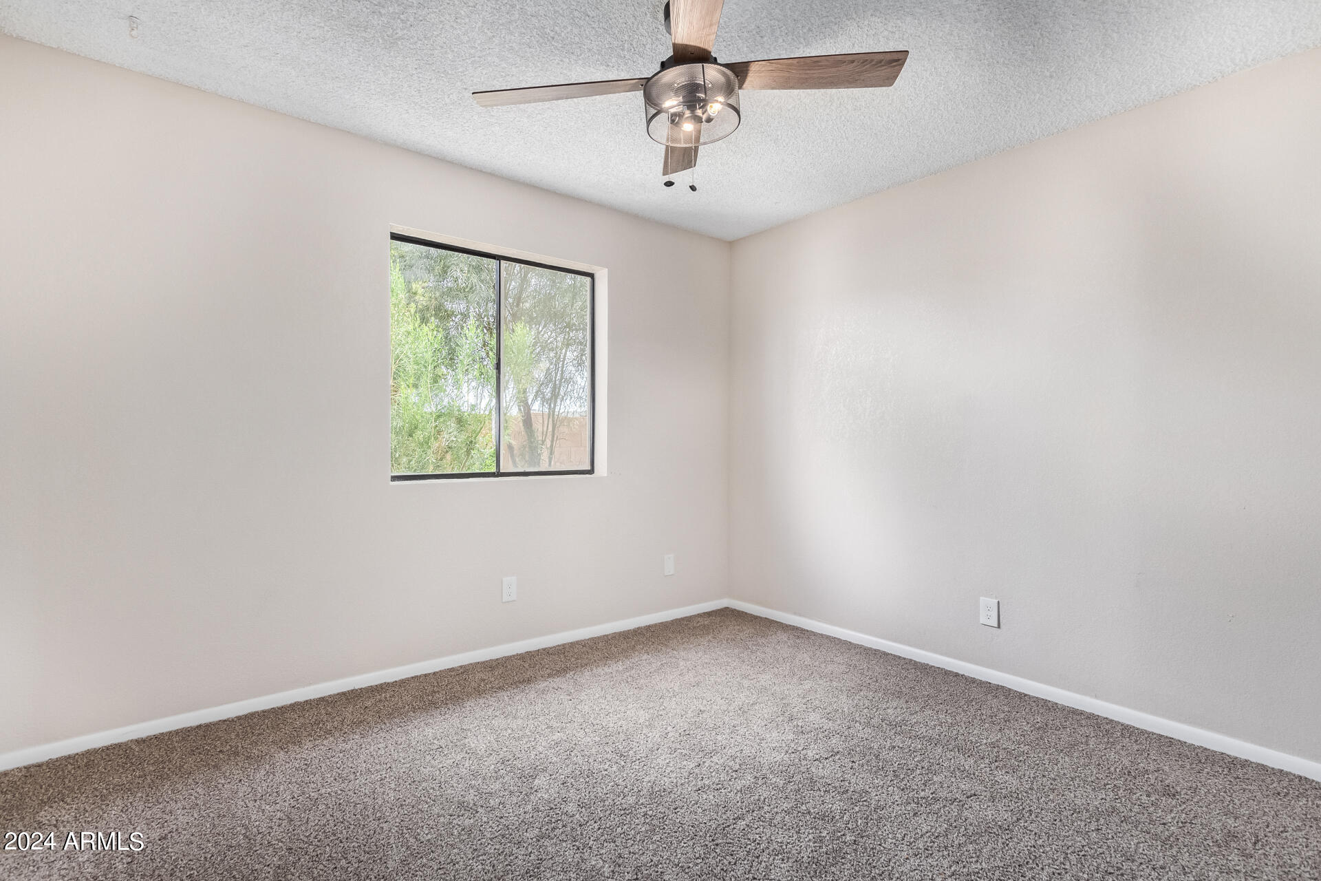 3917 West Juniper Avenue Phoenix, AZ 85053 - Photo 33 of 44 an empty room with a window and a ceiling fan
