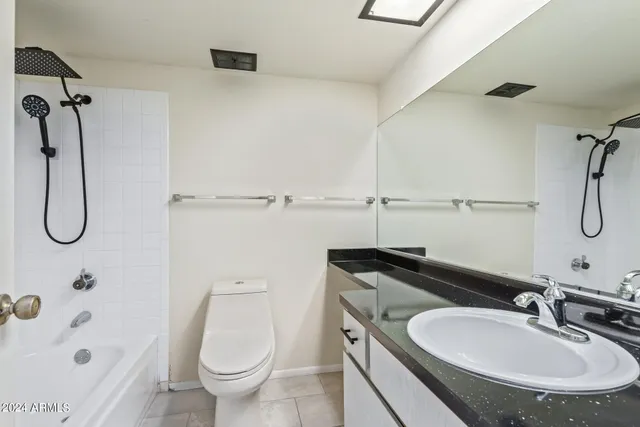a bathroom with a granite countertop sink a toilet and shower