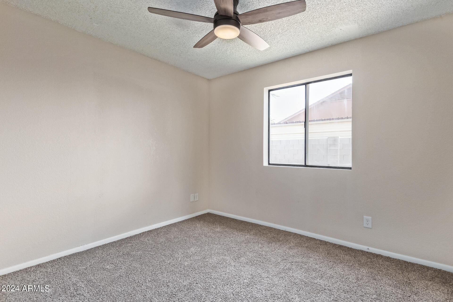 3917 West Juniper Avenue Phoenix, AZ 85053 - Photo 36 of 44 an empty room with a window and a ceiling fan