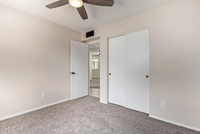an empty room with a ceiling fan and a window