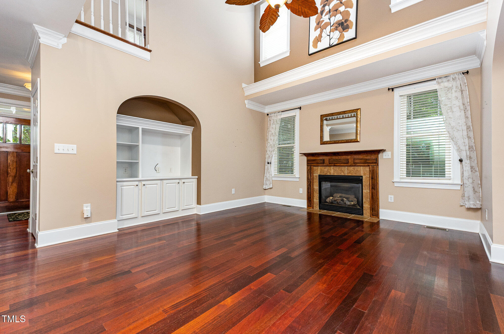 2201 Karns Place Raleigh, NC 27614 - Photo 6 of 31 an empty room with wooden floor a fireplace and windows