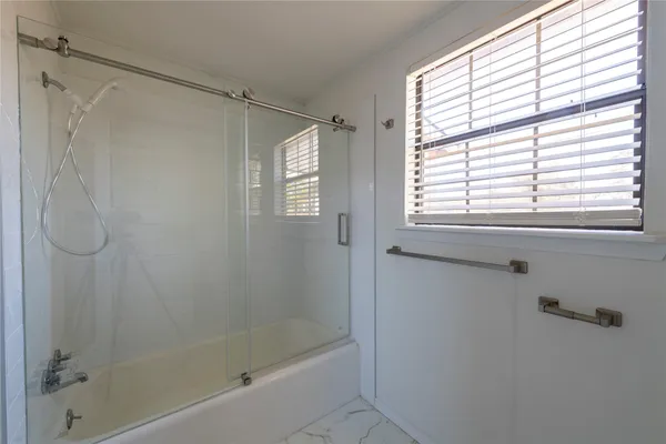 a bathroom with a shower and a window