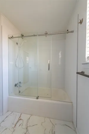 a bathroom with a shower and a bath tub