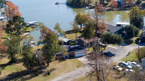 an aerial view of a house with a yard and lake view