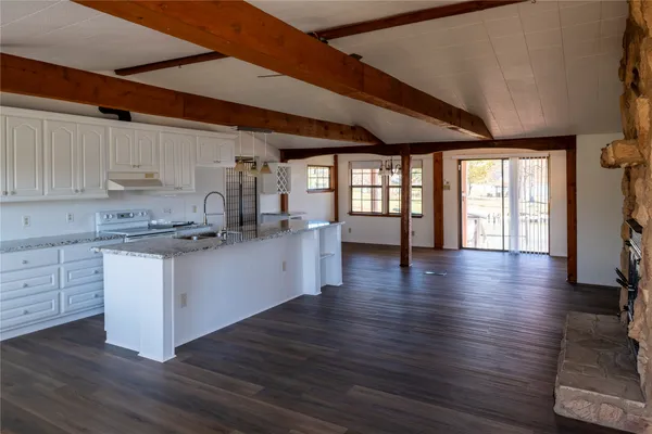 a kitchen with granite countertop wooden floors and white cabinets