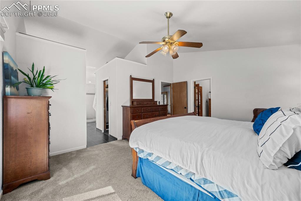 17815 Saddlewood Road Monument, CO 80132 - Photo 22 of 40 a bedroom with a bed and a chandelier