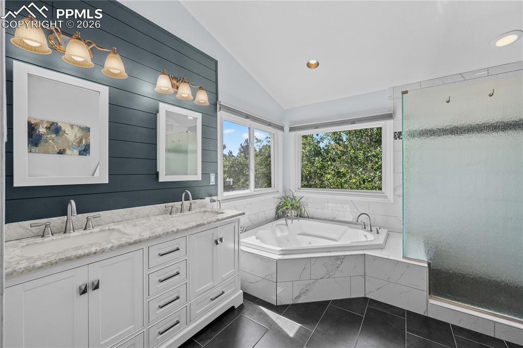17815 Saddlewood Road Monument, CO 80132 - Photo 32 of 40 a bathroom with a double vanity sink and mirror with bathtub