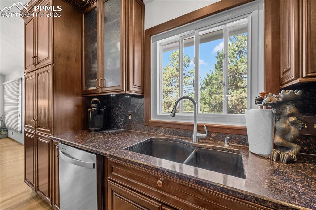 17815 Saddlewood Road Monument, CO 80132 - Photo 10 of 40 a kitchen with granite countertop a sink and a refrigerator