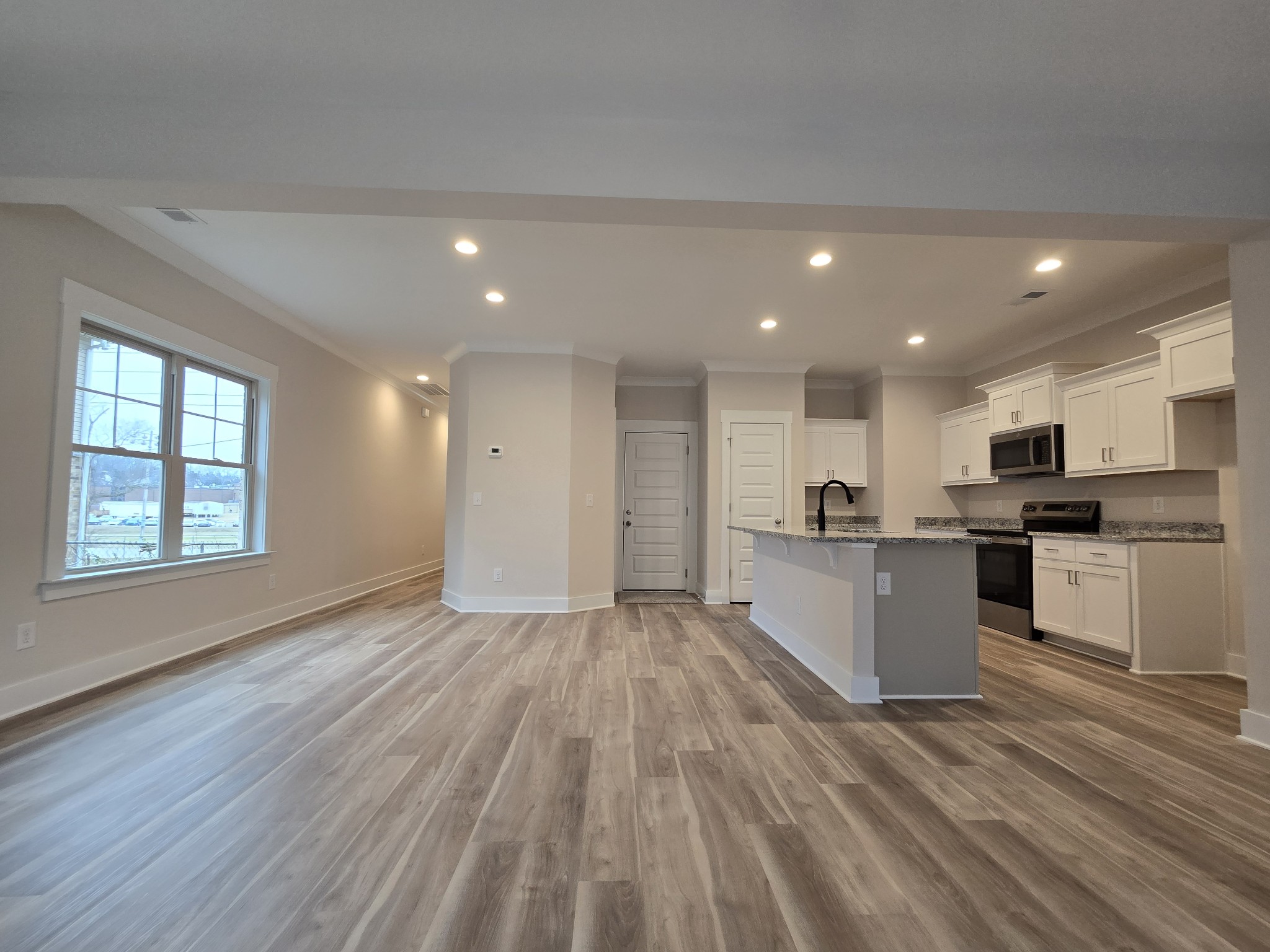 a view of kitchen with wooden floor and electronic appliances