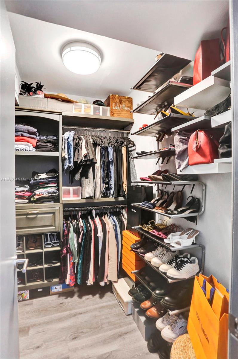 1037 Northeast 202nd Lane Miami, FL 33179 - Photo 14 of 21 a view of walk in closet with clothes and shoes