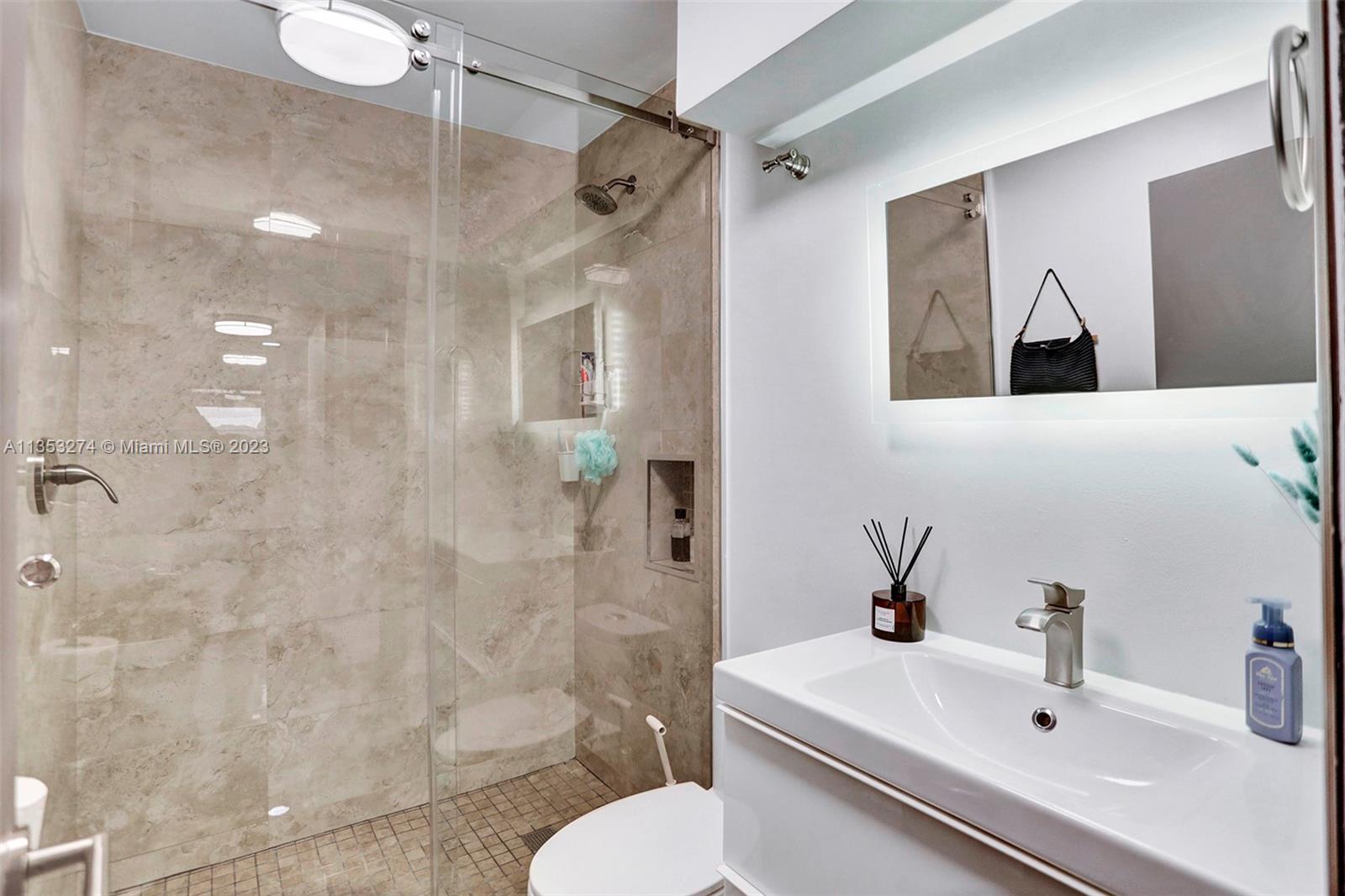 1037 Northeast 202nd Lane Miami, FL 33179 - Photo 16 of 21 a bathroom with a sink mirror toilet and shower