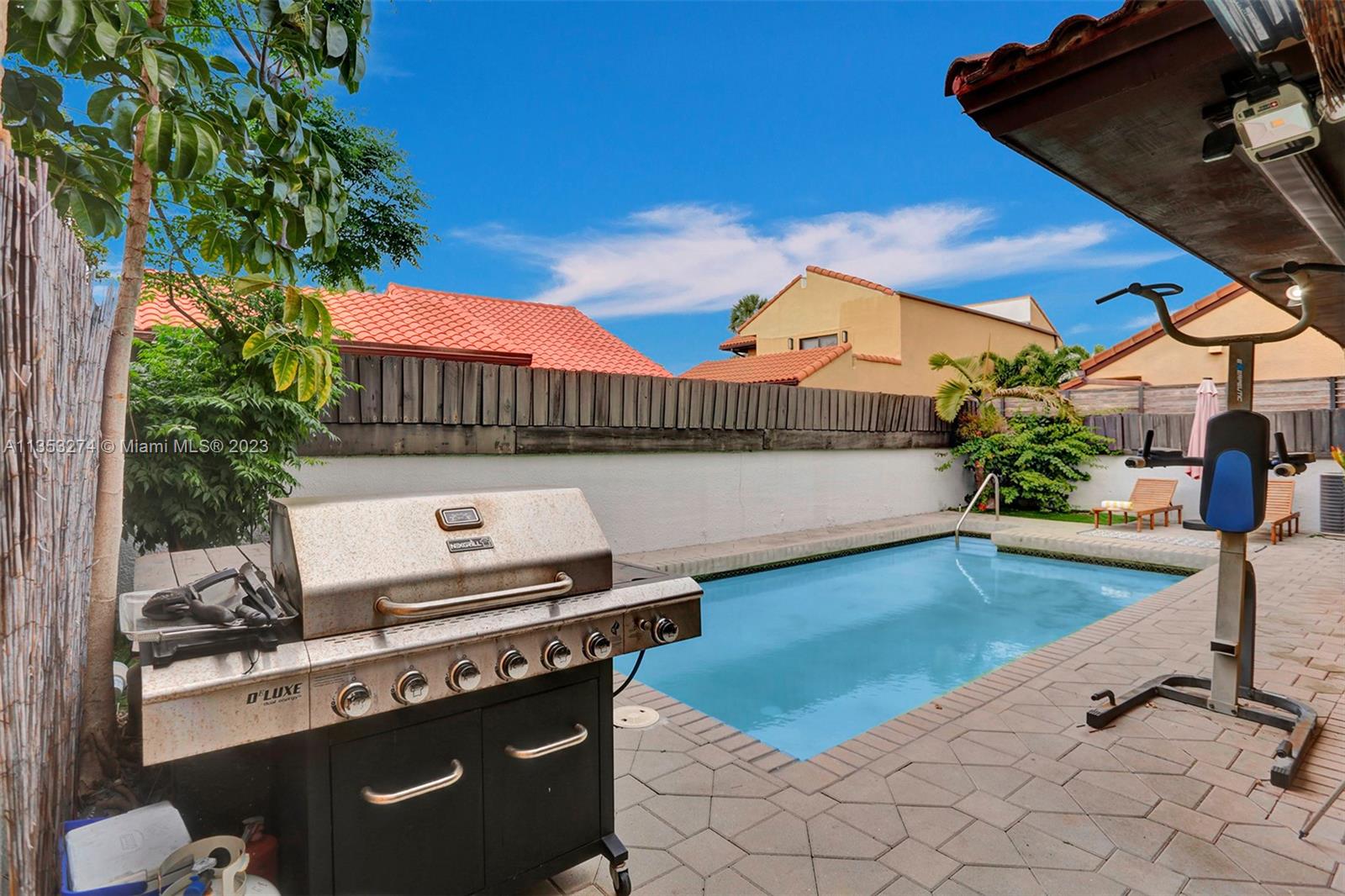 1037 Northeast 202nd Lane Miami, FL 33179 - Photo 18 of 21 a view of a backyard with plants and a patio