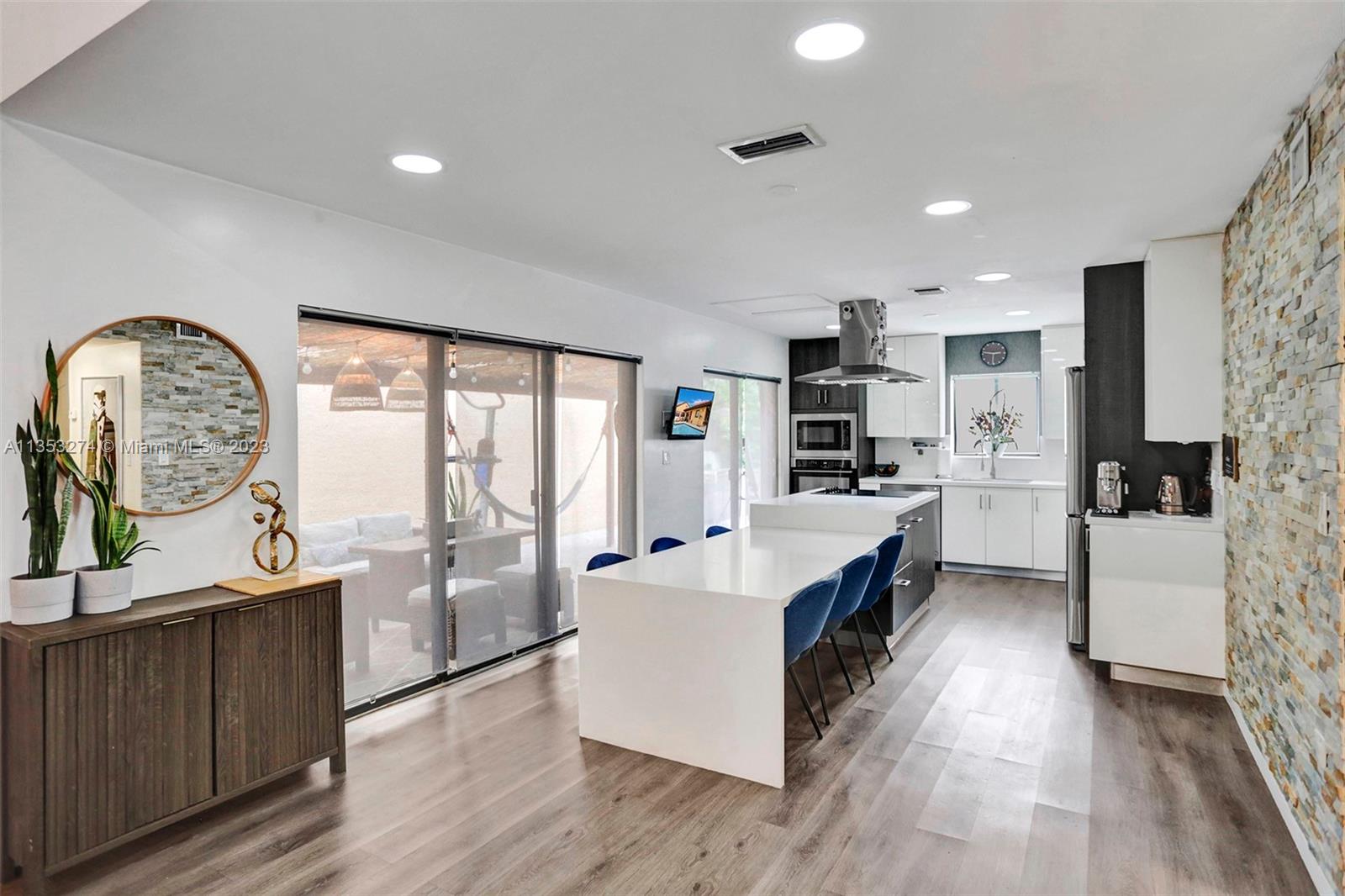 1037 Northeast 202nd Lane Miami, FL 33179 - Photo 5 of 21 a large kitchen with a large window a oven a stove and a wooden floors