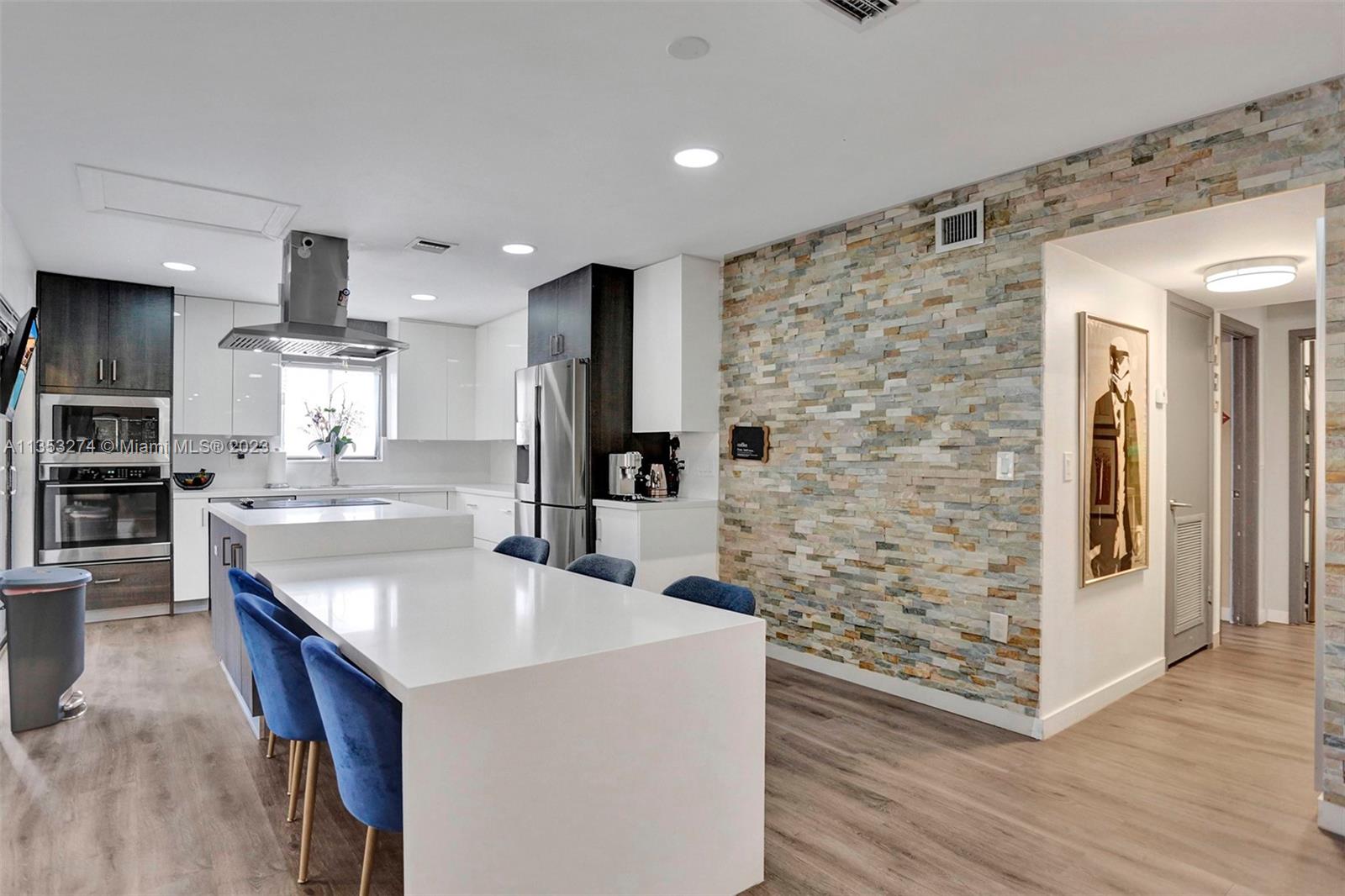 1037 Northeast 202nd Lane Miami, FL 33179 - Photo 8 of 21 a large kitchen with stainless steel appliances a large counter top a stove and a refrigerator