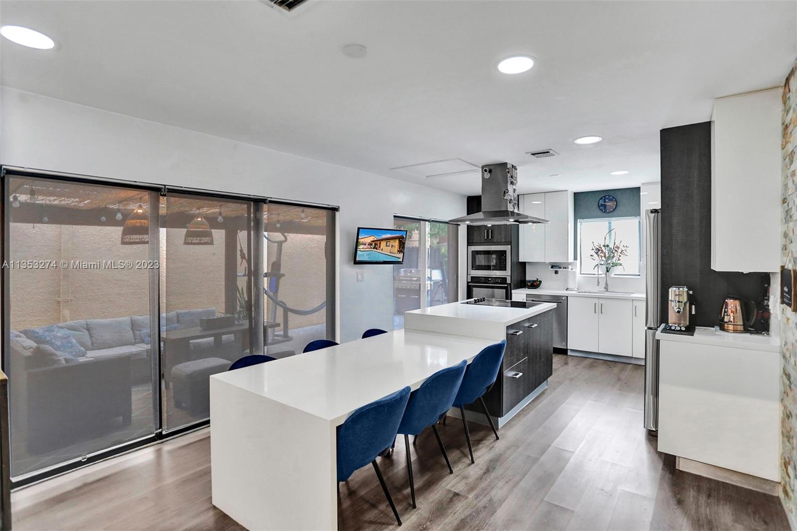 1037 Northeast 202nd Lane Miami, FL 33179 - Photo 9 of 21 a large kitchen with kitchen island a large counter space a sink stainless steel appliances and cabinets