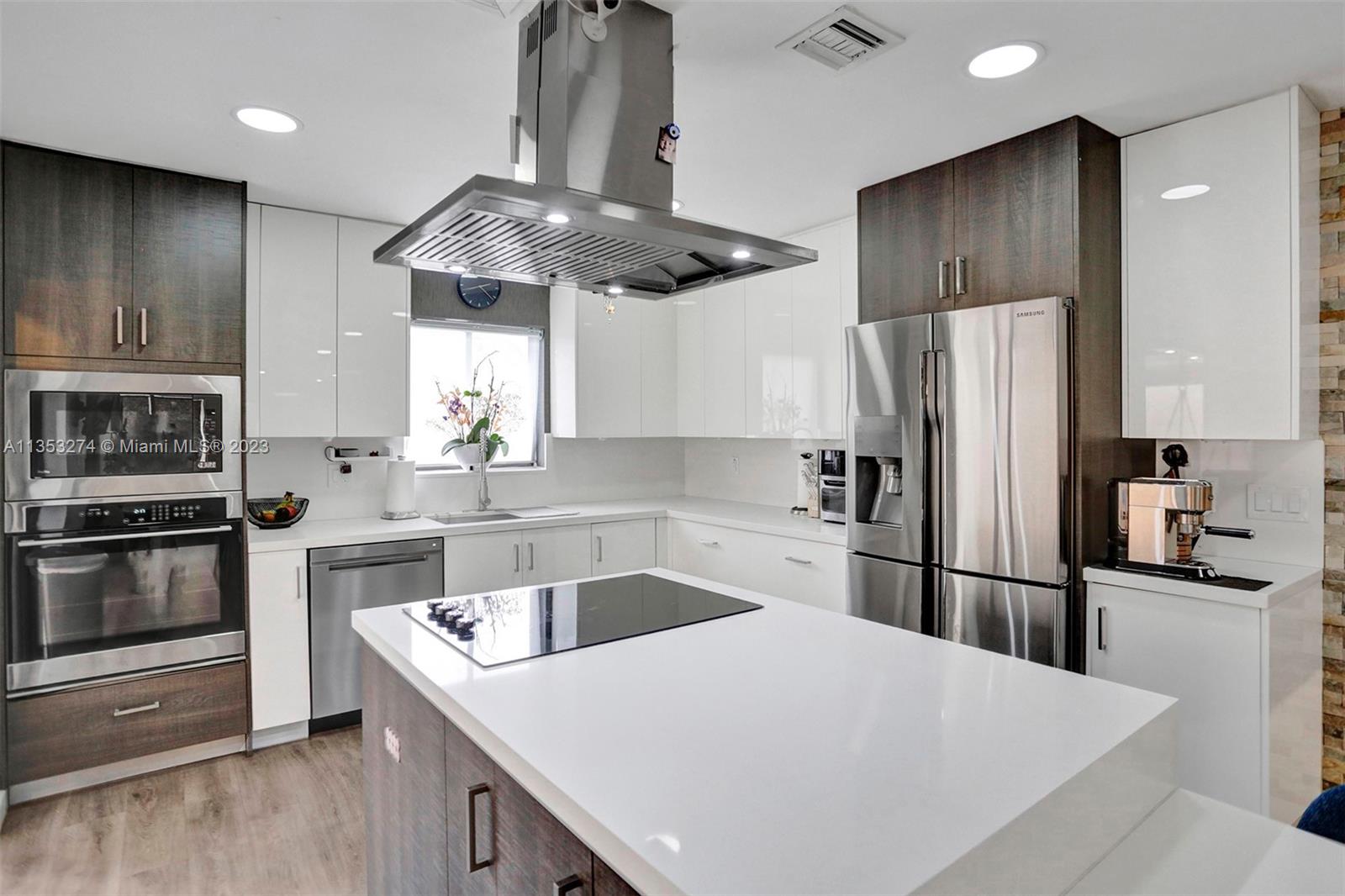 1037 Northeast 202nd Lane Miami, FL 33179 - Photo 10 of 21 a kitchen with stainless steel appliances granite countertop a sink stove and refrigerator