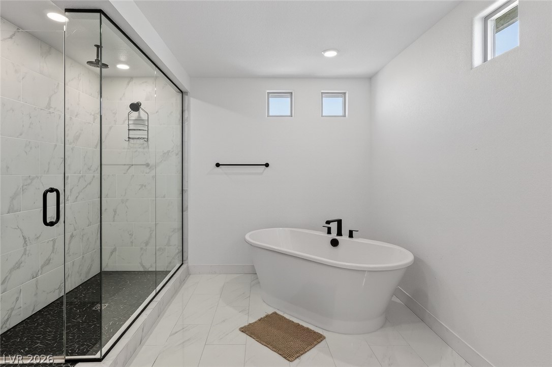 10446 Emerald Rye Street Las Vegas, NV 89183 - Photo 24 of 37 Luxurious bathing quarters with a contemporary standalone tub and an oversized shower enclosure.