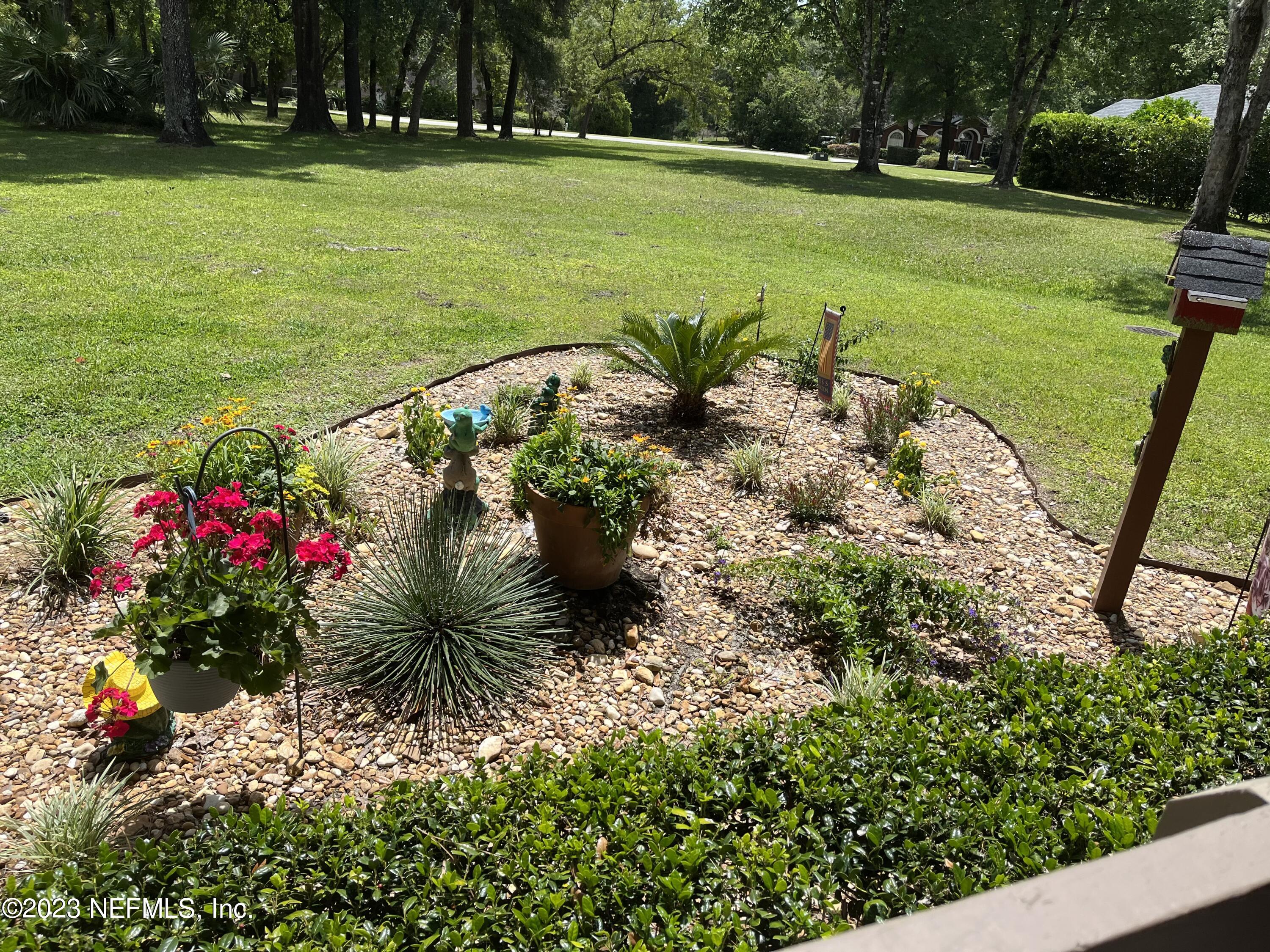 2910 Ravines Road, Unit 1102 Middleburg, FL 32068 - Photo 39 of 43 a view of a garden with plants and large trees