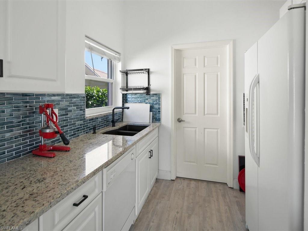 360 Fox Den Circle Naples, FL 34104 - Photo 13 of 41 a kitchen with granite countertop a sink and a wooden cabinets