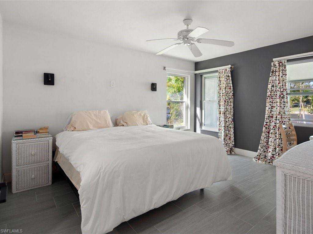 360 Fox Den Circle Naples, FL 34104 - Photo 18 of 41 a bedroom with a bed and a chandelier