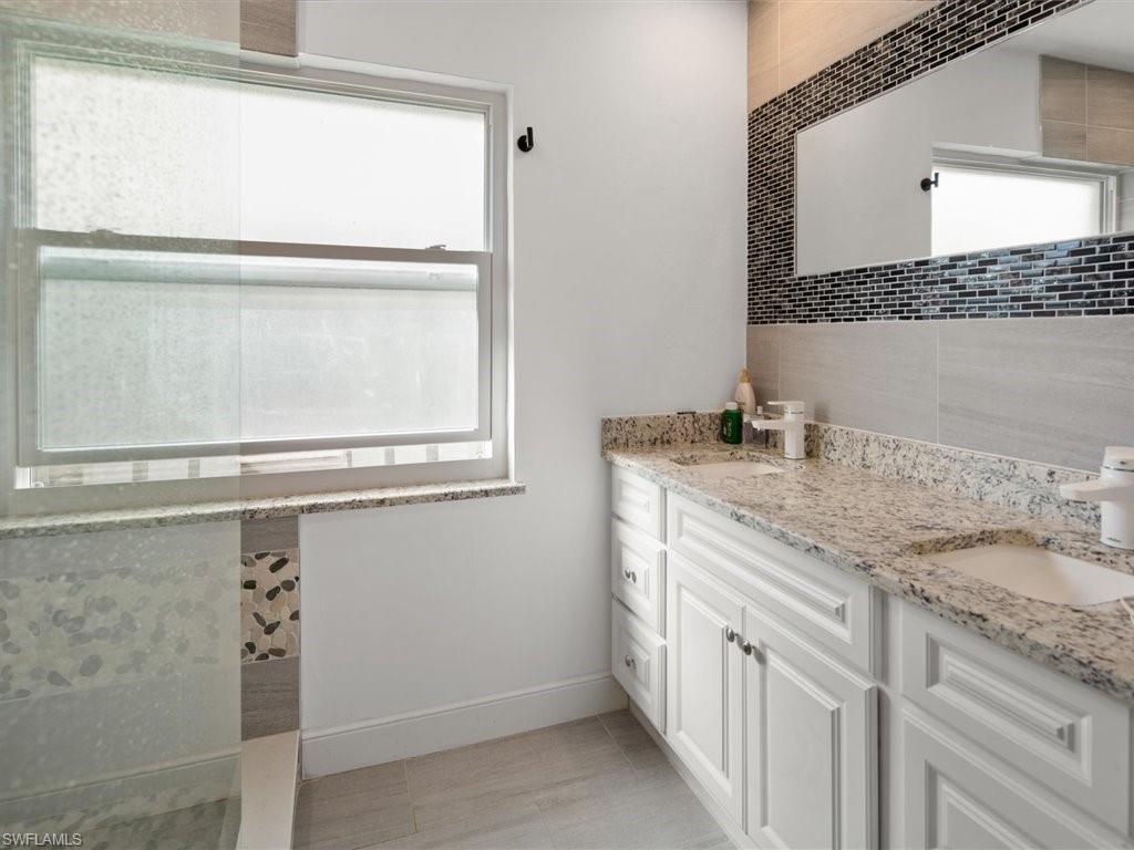 360 Fox Den Circle Naples, FL 34104 - Photo 21 of 41 a bathroom with a granite countertop sink a mirror and a window