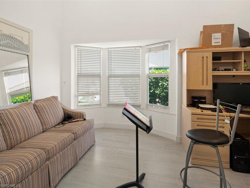 360 Fox Den Circle Naples, FL 34104 - Photo 23 of 41 a living room with furniture a flat screen tv and a window