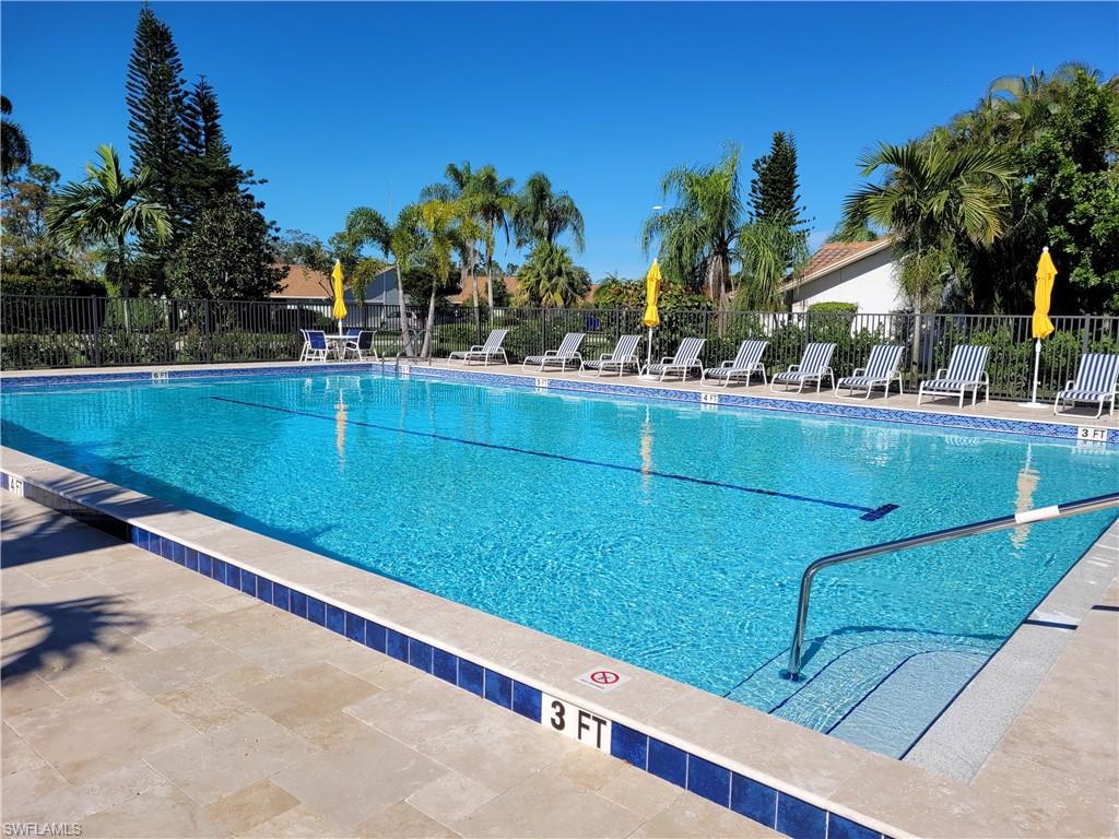 360 Fox Den Circle Naples, FL 34104 - Photo 33 of 41 a view of a pool with a bench and palm trees