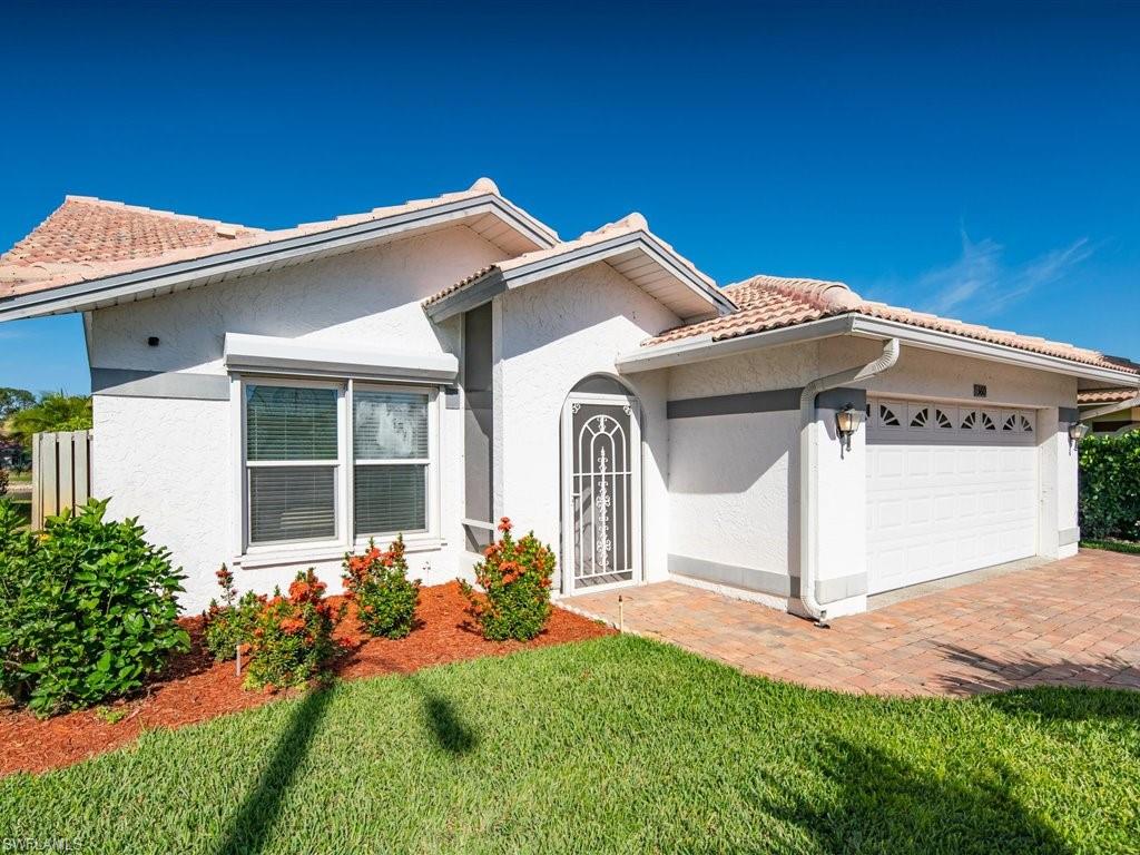 360 Fox Den Circle Naples, FL 34104 - Photo 5 of 41 a front view of a house with garden